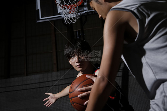 室内篮球馆打篮球的青年男子图片