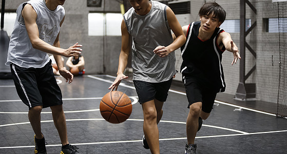 在体育馆打篮球的年轻人图片