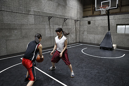 篮球运动员在室内篮球场打球图片