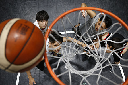 年轻男性在室内篮球场打球图片