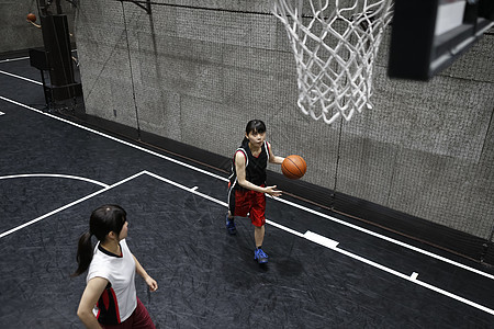 年轻女子在室内篮球场打球图片