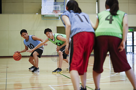 体育馆打篮球运球的青年男子图片