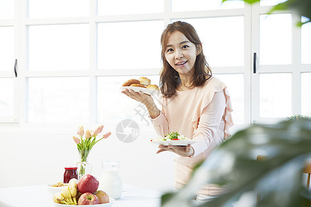 拿着食物餐盘微笑的年轻女性图片