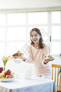 拿着食物餐盘开心微笑的年轻女性图片