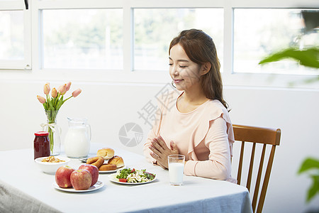 用餐前祈祷的年轻女性图片