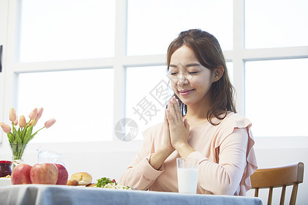 用餐前闭眼祈祷的女青年图片
