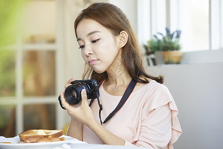 年轻女孩手拿相机记录生活图片