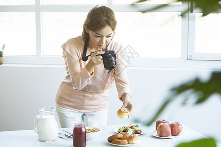 拿着相机拍摄食物照片女青年图片