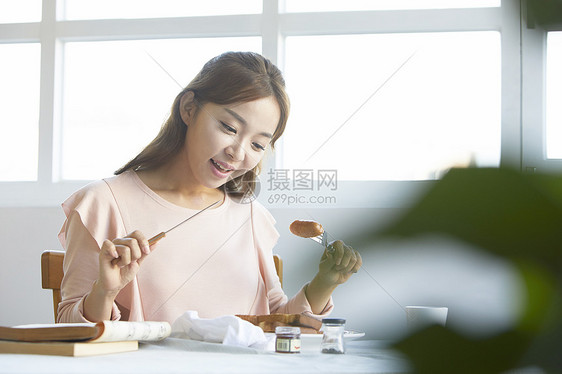 享用早午餐开心的年轻女子图片