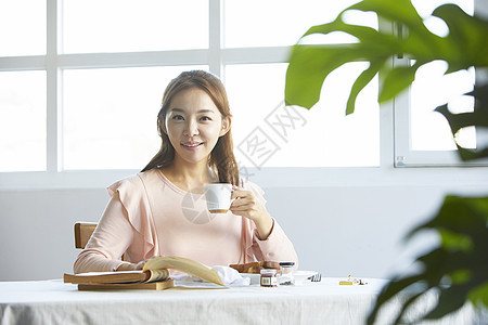 咖啡馆里喝咖啡的优雅女性图片