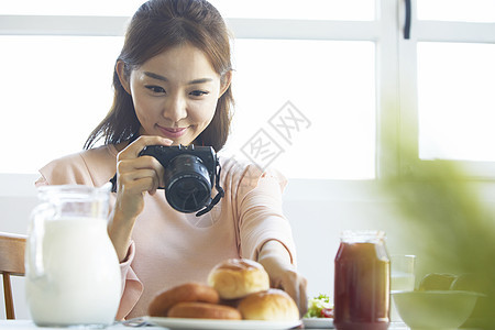 咖啡馆拿着相机拍食物图片的女性图片