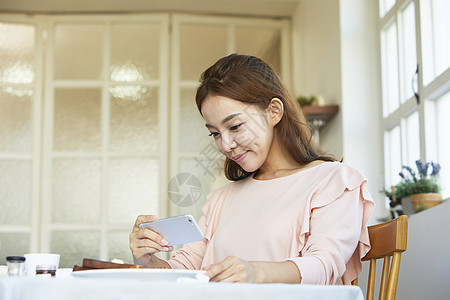 给美食拍照的年轻女子图片