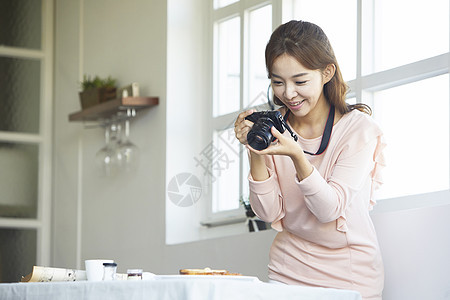 给美食拍照的年轻女子图片