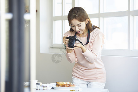 年轻女子使用相机记录生活图片