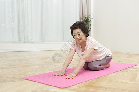 瑜伽垫上做瑜伽的成年女子图片