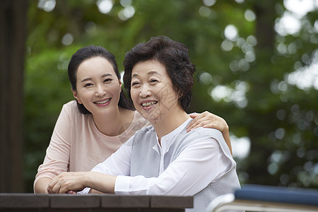 年轻女子扣环前视图拥抱幸福妈妈女儿图片