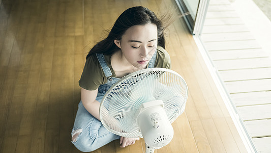 夏天坐着在家吹风扇的妇女图片