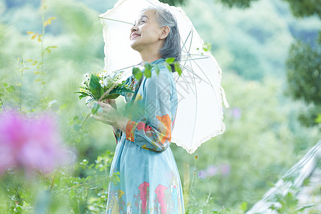 在院子里撑伞的老年阿姨图片
