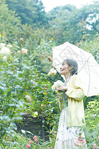 庭院里打着遮阳伞的老夫人图片