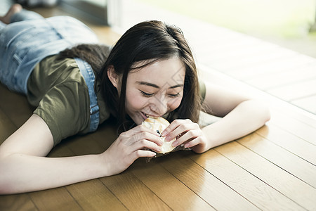 趴在地板上吹东西的少女图片