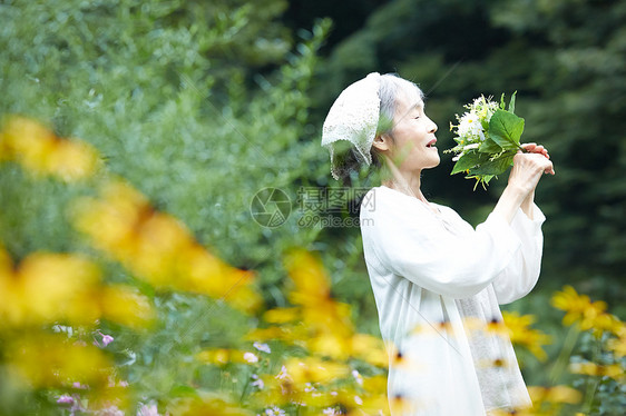 花园里捧着花束开心的老年女性图片