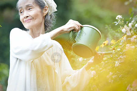 花园里浇水的老年女性图片