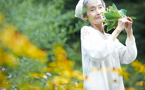 拿着一束花微笑的女性图片