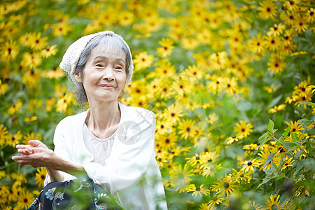 老年妇女在庭院里采花背景图片