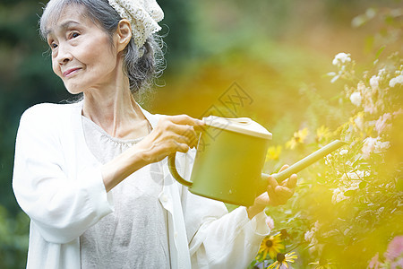 老年妇女在庭院里浇水图片