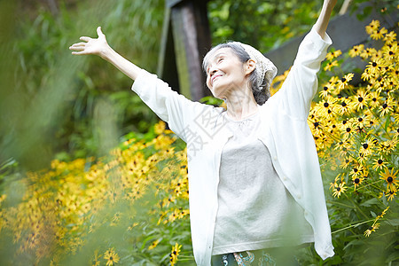 院子植物的自然放松的老年妇女图片