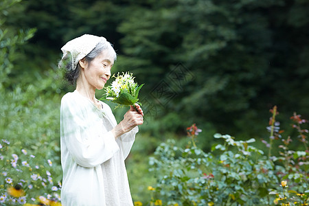 闻到花的气味的老年妇女图片