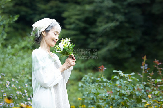 闻到花的气味的老年妇女图片