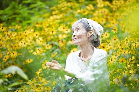 院子植物的自然放松的老年妇女图片