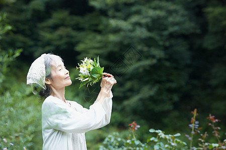闻到花的气味的老年妇女图片