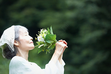 闻到花的气味的老年妇女图片