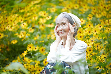 院子植物的自然放松的老年妇女图片