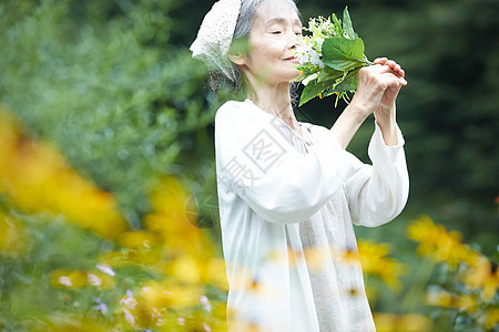 闻到花的气味的老年妇女图片