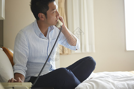 精美亚洲30多岁男子在酒店打电话图片