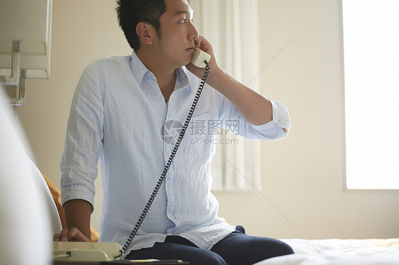 坐着孤独的男人们男子在酒店打电话图片