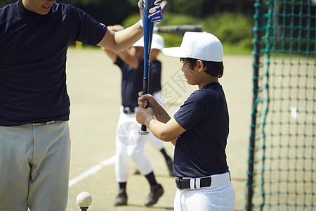 男子两个人制服男孩棒球男孩练习击球图片