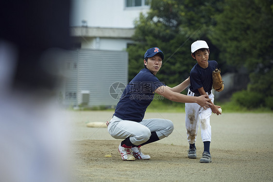 日本伸出坚持的男孩棒球运动员实践的投球画象图片