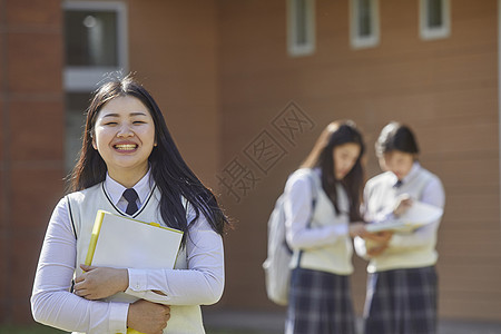 高中生手抱书本形象背景图片