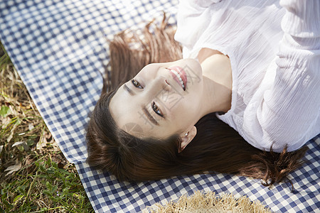 躺在野餐垫上休息的女青年图片