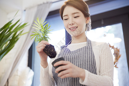 手上拿着植物的青年女性图片