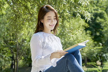 户外阅读书籍的女性图片