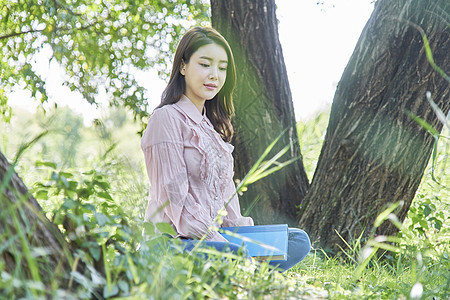 坐在公园里放松的女大学生图片