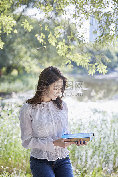 公园里拿着书的女大学生图片