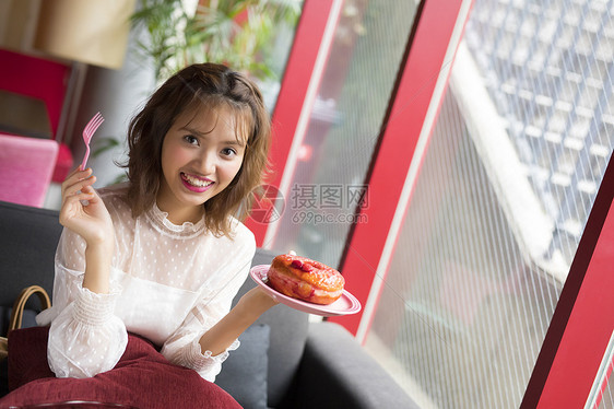 在甜品店享用美食的妇女图片