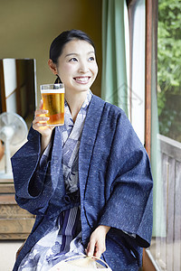 和服美女坐在窗边饮用的啤酒图片