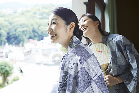 遵守房间窗边享受温泉旅行的妇女图片